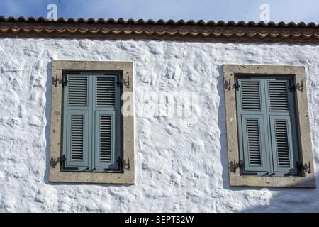 A vibrant rustic windows Mediterranean charm through vivid shutters and textured stone facades Stock Photo