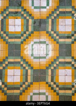 Abstract decorative ceramic tile floor with repeating geometric circles and squares in green, yellow and white, creating a vintage ornamental backgrou Stock Photo