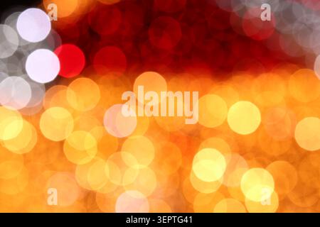 Sunset-toned bokeh background transitions from deep red at top to glowing amber and yellow below. Layered light circles create rich, luminous depth, g Stock Photo