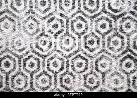 Texture of wool carpet with monochrome honeycomb pattern. Backdrop of wool rug with hexagon motif of gray, light grey and black colors Stock Photo