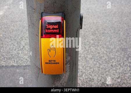 Pedestrian or pelican crossing with call button displaying signal kommt in germany Stock Photo