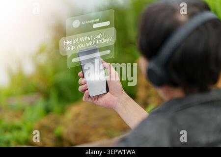 Unrecognizable person using smartphone with holographic AI assistant chatbot interface outdoors Stock Photo