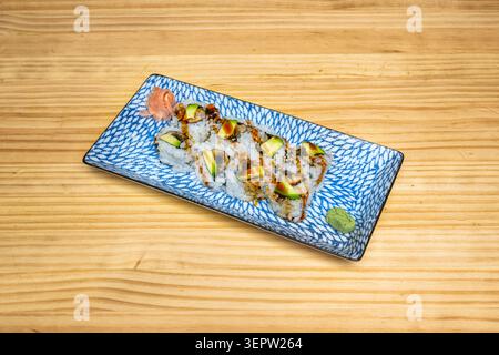 A plate of uramaki decorated with sauce motifs, showing the different types arranged in rows or a circle around the plate. Stock Photo