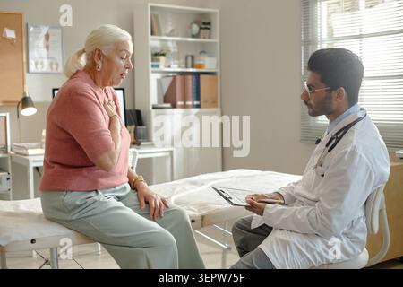 Senior Woman Consulting Doctor during Medical Checkup in Clinic Stock Photo