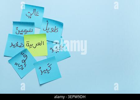 Arabic language learning with sticky notes on blue background, educational vocabulary development, educational development and the process of acquirin Stock Photo