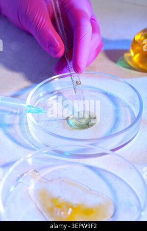 Laboratory research with pipette and syringe in petri dish, scientific experimentation and medical innovation, meticulous process of discovery in biot Stock Photo