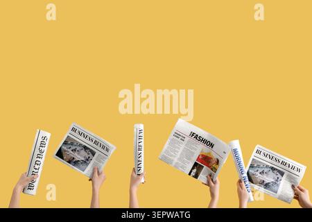 Women with newspapers on yellow background Stock Photo