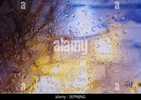 Water droplets on the surface create an abstract texture effect with blurred lights. High quality photo Stock Photo