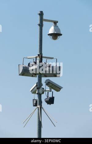 Security surveillance CCTV cameras and floodlights mounted on a metal pole Stock Photo