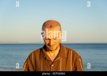 Close-up of Man Looking Down with Visible Scabs After Hair Transplant Stock Photo