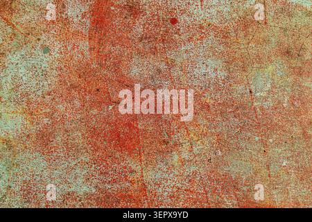 A distressed concrete surface featuring deep cracks and peeling reddish-brown layers, highlighting industrial aging and decay Stock Photo
