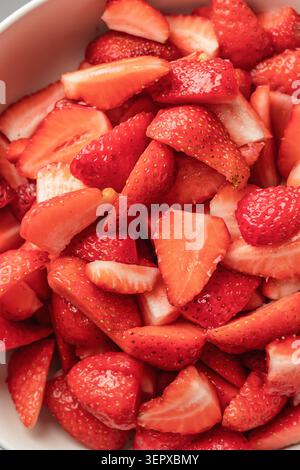 Process of making a strawberry pie tart filling. Fresh cutted berries in a bowl. Home baking culinary concept, recipe Stock Photo