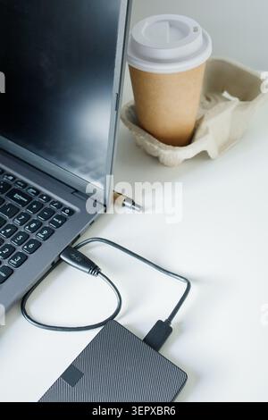 Using external hard drive disk through usb cable connection to laptop. Saving data on different sources, safe data security, computer memory unloading Stock Photo