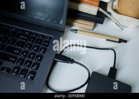 Using external hard drive disk through usb cable connection to laptop. Saving data on different sources, safe data security, computer memory unloading Stock Photo