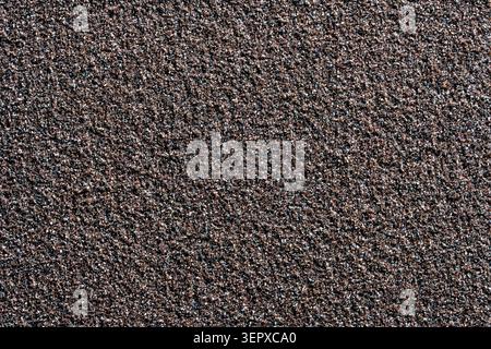 Sandpaper texture, background pattern of black sand grains on sandpaper, close up, top view Stock Photo