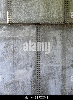 Vertical close up of a weathered galvanized iron water tank surface with water spots, white deposits, scratches Stock Photo