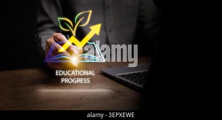 Businessman pointing at digital icon of open book with rising growth arrow and growing leaves on dark copy space. Continuous educational progress, per Stock Photo