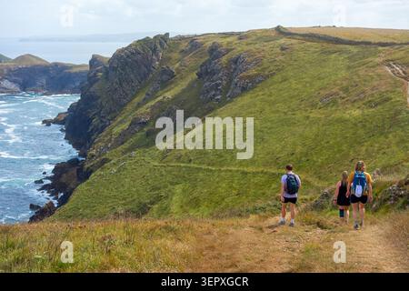 Hikers on South West Coast Path near Polzeath and Port Isaac in North Cornwall on a Sunny but Cloudy Day Stock Photo