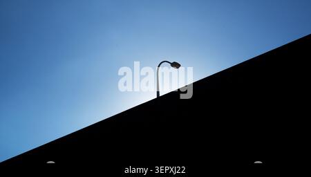 Minimalist silhouette of a street lamp on an overpass against a clear blue sky in Tokyo Japan Stock Photo