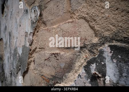 Close up view of weathered brick wall and peeling plaster Stock Photo