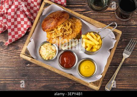 Crispy chicken burger with fries and sauces rustic fast food meal Stock Photo