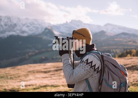 Photographer taking pictures of alpine scenery in the Dolomites during autumn. Outdoor adventure and landscape photography in the Italian Alps Stock Photo