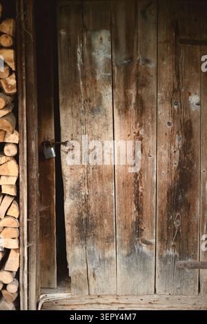 Old wooden door with rustic texture in natural light. Vintage background with weathered surface and countryside atmosphere Stock Photo