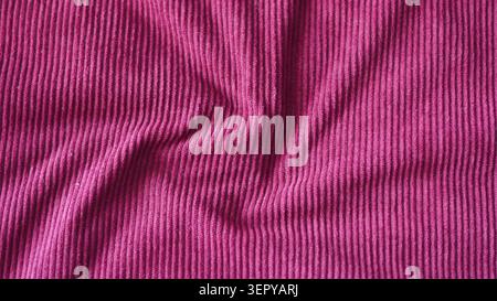 Pink crumpled corduroy ribbed fabric texture close up. Stock Photo