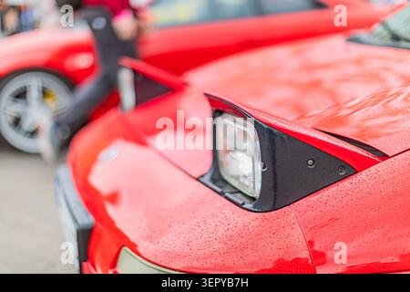 Red sports car front view, highlighting sleek aerodynamic design, featuring high-quality paint finish, showcasing water droplets for dynamic effect, e Stock Photo