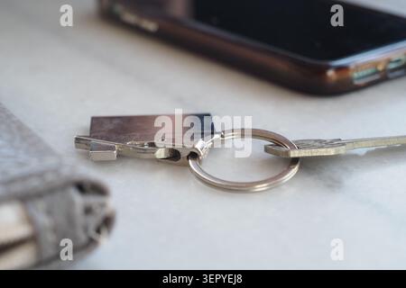 Keys and phone on a table in a casual setting Stock Photo