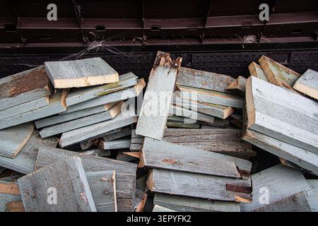 A domestic log store filled with sawn up commercially pre-used and painted wood Stock Photo