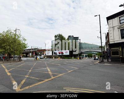 Manchester, UK - May 07, 2026: Wide Manchester UK junction with traffic lights, billboards and pedestrians by modern office buildings. Stock Photo