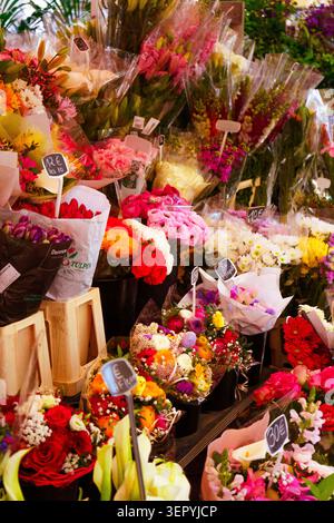 Vibrant flower bouquets with handwritten price tags displayed at the famous Marché aux Fleurs market in Cours Saleya, Nice, France. Vertical shot. Stock Photo