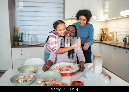 Happy family cooking pizza together in modern kitchen Stock Photo