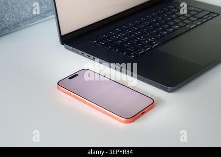 Poznan, Greater Poland, Poland, June 13, 2026, Laptop keyboard open screen smartphone blank mockup workspace desk business technology office. A modern Stock Photo