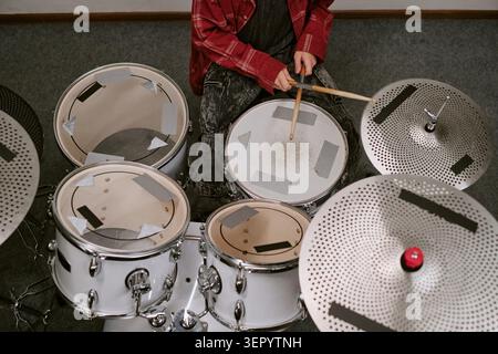 Teenager Practicing Drum Kit Technique for Music Training Program Stock Photo
