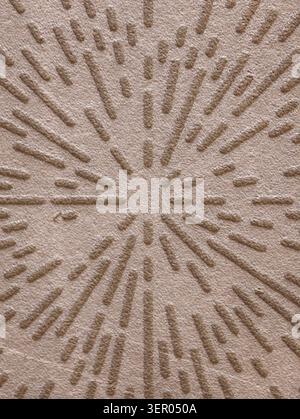 Close-up view of a neutral beige carpet featuring a raised radial sunburst texture. Soft pile and cut-loop construction create alternating low and hig Stock Photo