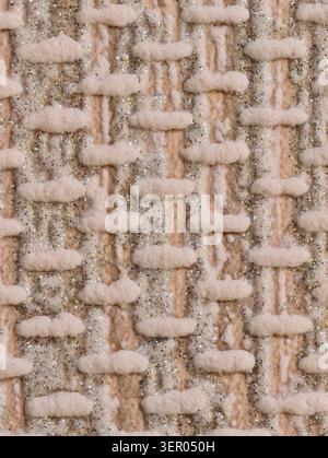 Close-up of a cream-colored woven textile featuring thick wool yarns and raised looped stitches interlaced with metallic glitter threads. The image sh Stock Photo