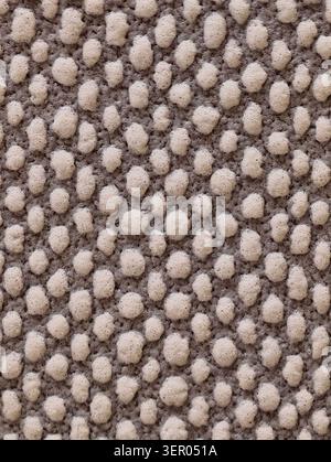 Tight close-up view of a loop-pile carpet showing tightly packed rounded yarn tufts in a pebble-like pattern. Neutral beige and light gray fibers crea Stock Photo