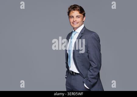 Young handsome business man dressed in casual classic suit, isolated on gray background Stock Photo