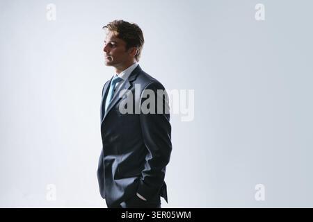 Young handsome business man dressed in casual classic suit, isolated on gray background Stock Photo