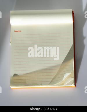 Small paper notepad with blank or lined pages on a clean background, a practical stationery item for notes, lists, planning and office organization Stock Photo