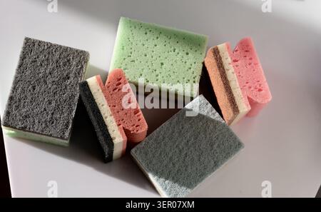 Colorful household cleaning sponges and scouring pads arranged on a clean background, representing hygiene, dishwashing and domestic chores Stock Photo