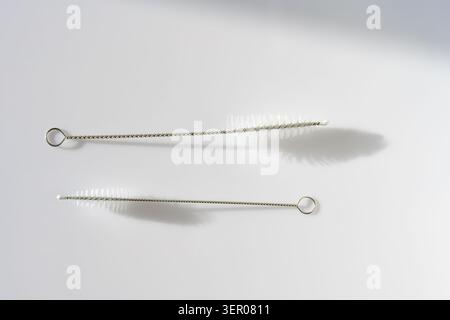 Slim metal wire cleaning brush with loop handle on a clean background, a practical tool for tubes, straws and precision maintenance Stock Photo