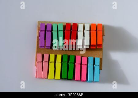 Colorful miniature wooden clothespins arranged in neat rows, a creative craft and stationery accessory for decoration, organization and DIY projects Stock Photo