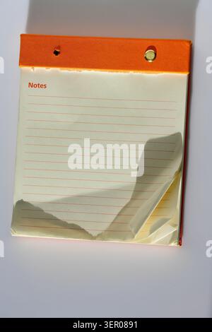 Small paper notepad with blank or lined pages on a clean background, a practical stationery item for notes, lists, planning and office organization Stock Photo