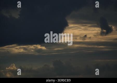Storm clouds illuminated by evening sunlight over rural countryside landscape Stock Photo