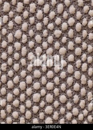 Detailed close-up view of a loop-pile wool carpet showing densely packed round tufted loops forming a pebble-like repeating pattern. Neutral beige and Stock Photo