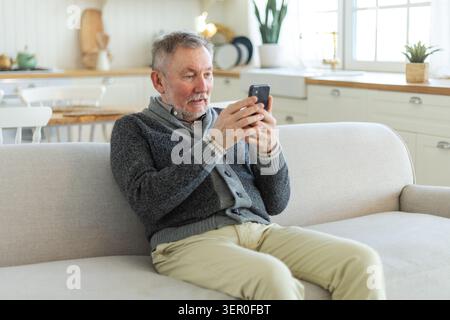 Happy middle aged senior man talk on video call with friends family. Laughing mature old senior grandfather having fun speaking with grown up children online. Older generation modern tech usage Stock Photo
