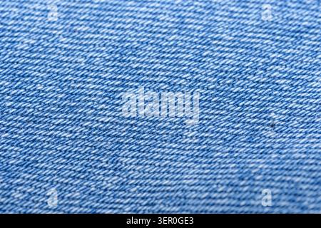Macro shot of blue denim fabric showing diagonal weave, textile texture and detailed threads, ideal as a fashion, textile or background image. Stock Photo